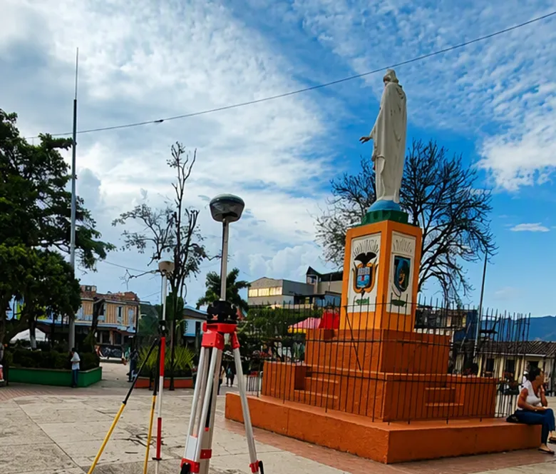 Equipos topográficos montados en la plaza de un casco urbano durante un levantamiento predial