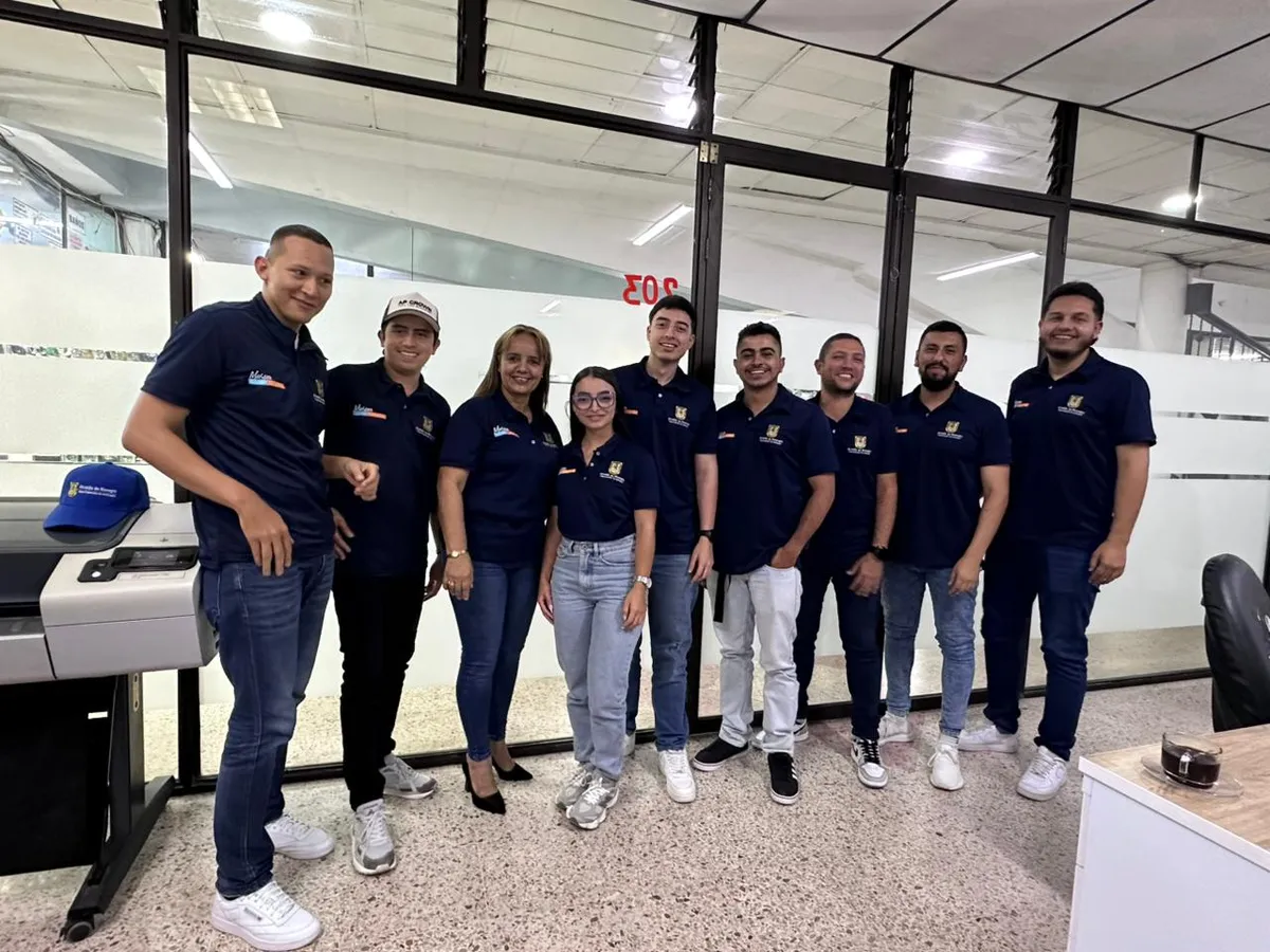 El equipo de SICO S.A.S. reunido en la sede, junto a los equipos de impresión de planos